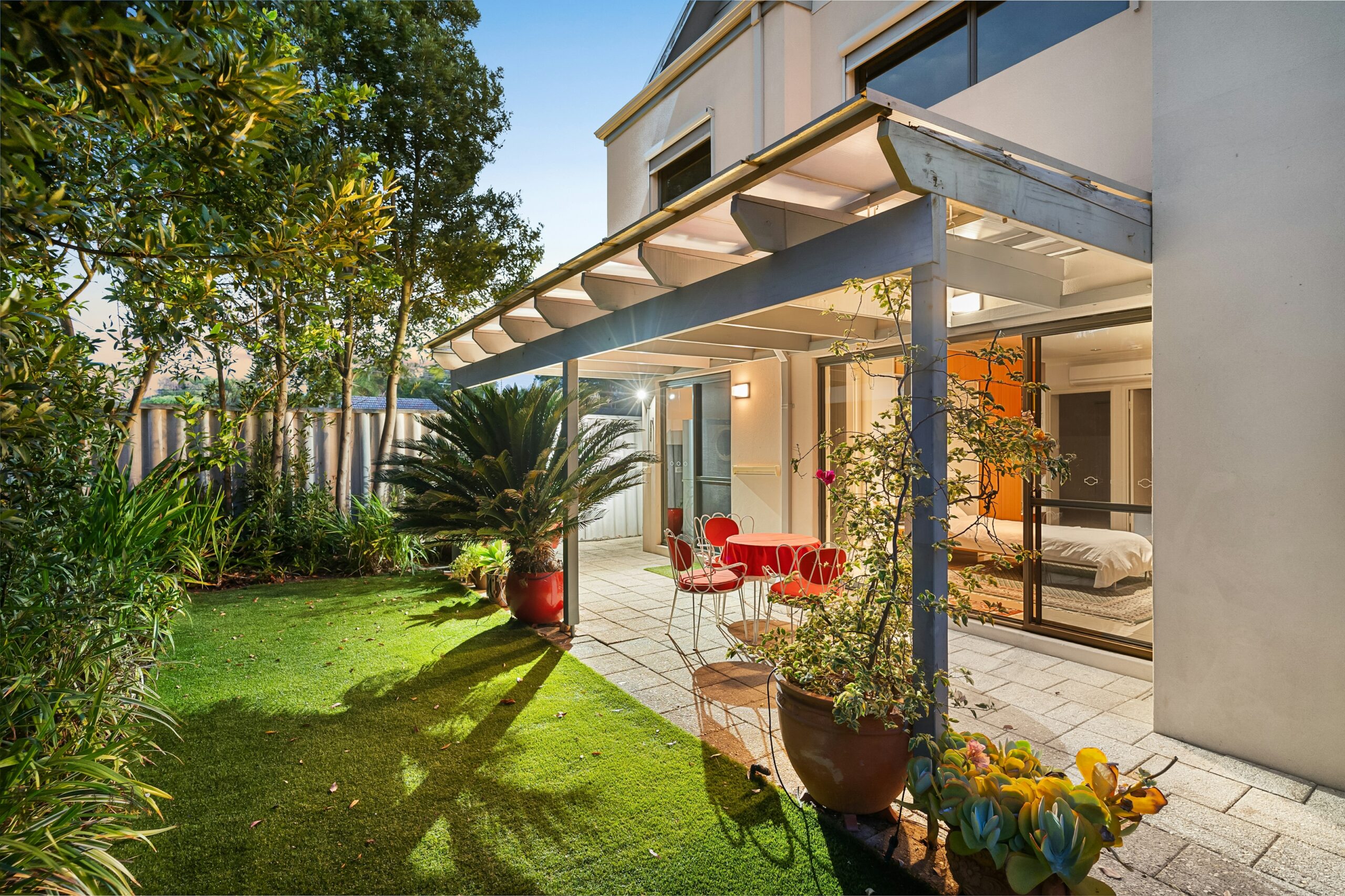 Covered backyard patio with seating and landscaping